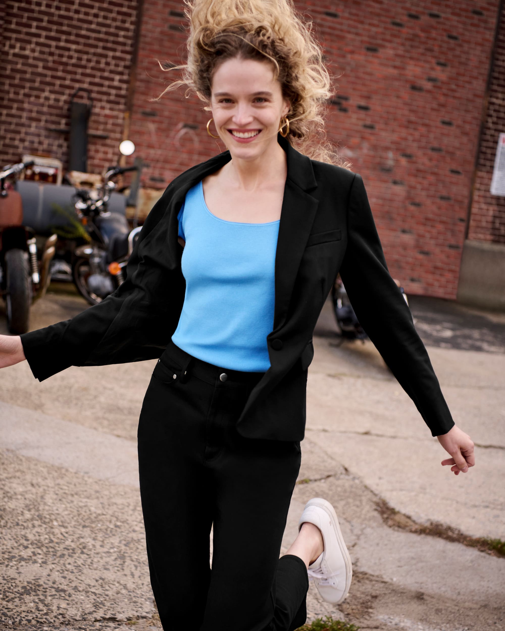 image of a woman wearing a black jacket, blue top and black pants