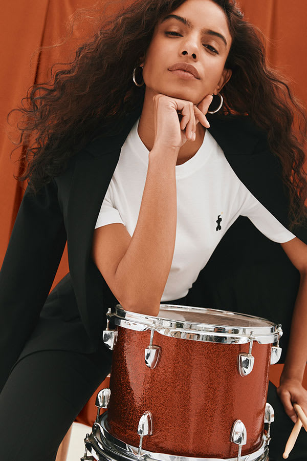 image of a woman in front of a drum wearing the leslie t-shirt in icon embroidery