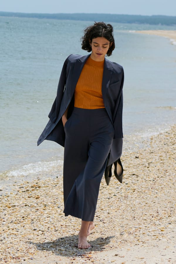 image of a woman walking down the beach wearing a cool charcoal suit