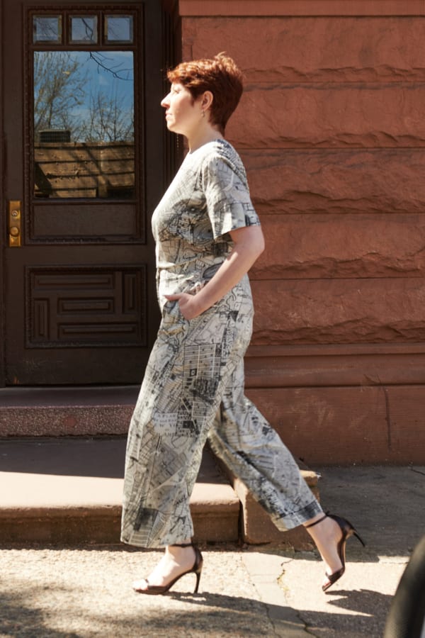 woman wearing matching short-sleeve Annika top and wide-leg Zhou culotte in borough map print, walking in the sun with her hands in her pockets