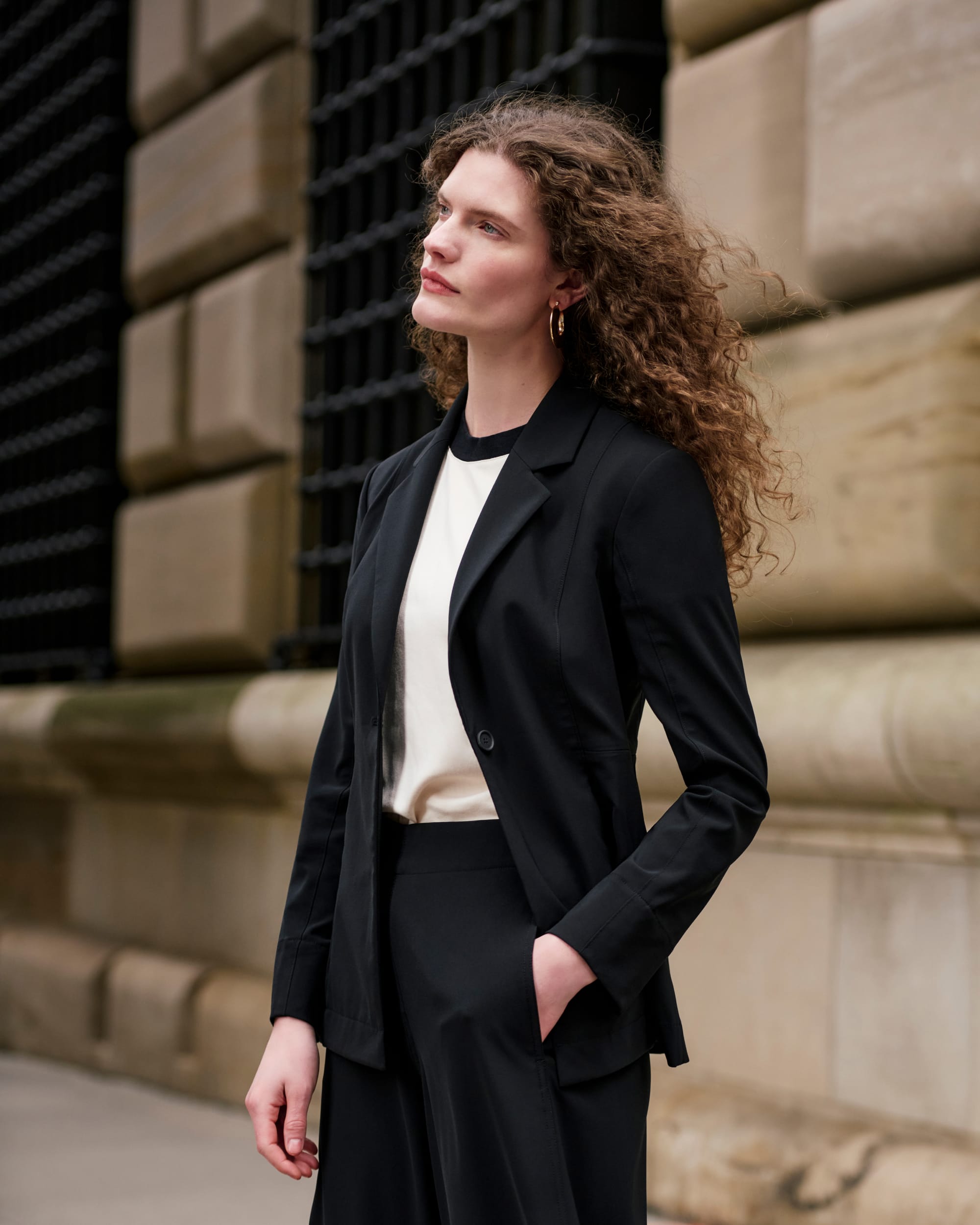 image of a woman wearing the moreland jacket and elena culottes in black with the leslie tee