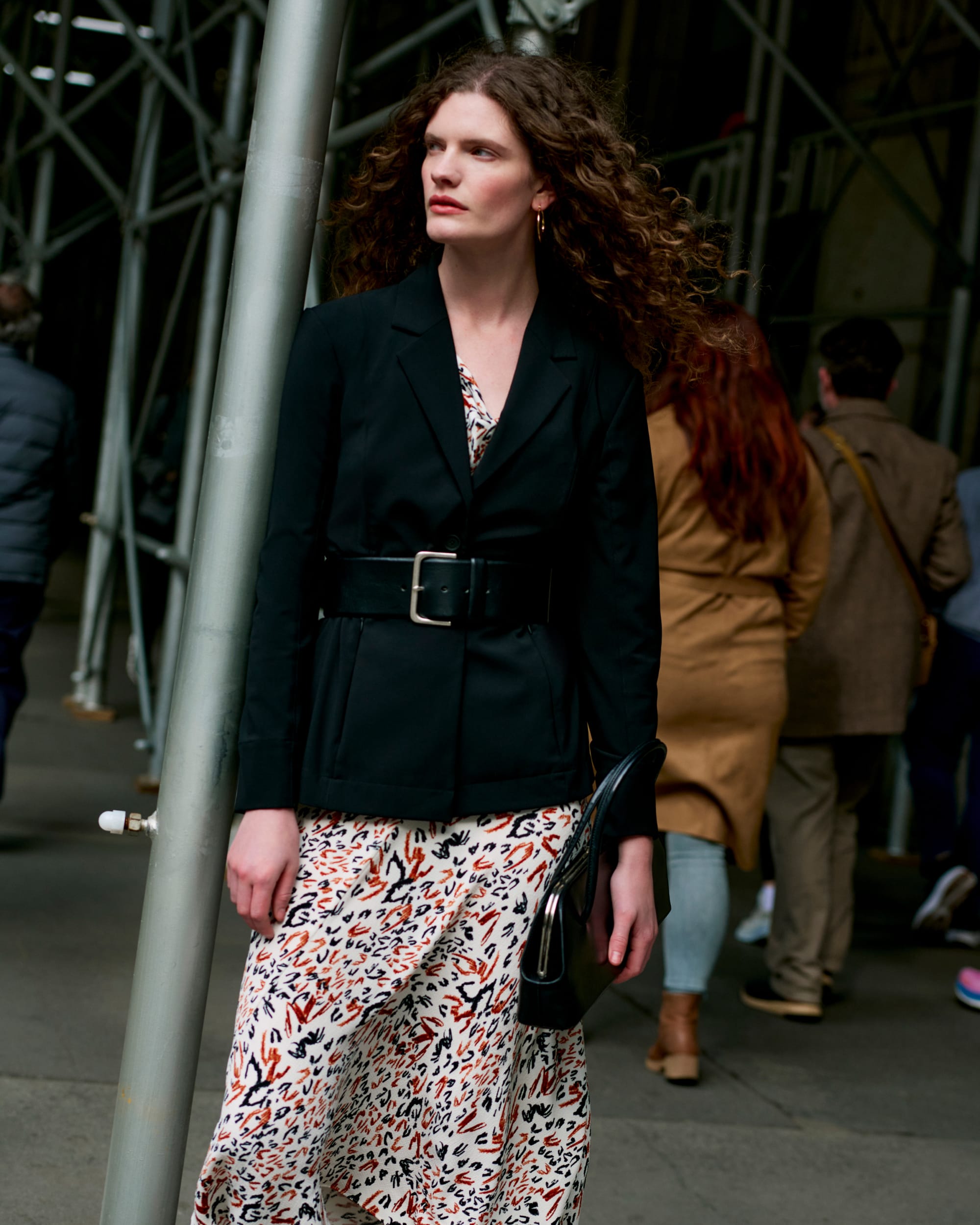 image of a woman wearing the moreland jacket in black over the priya dress in leopard sketch