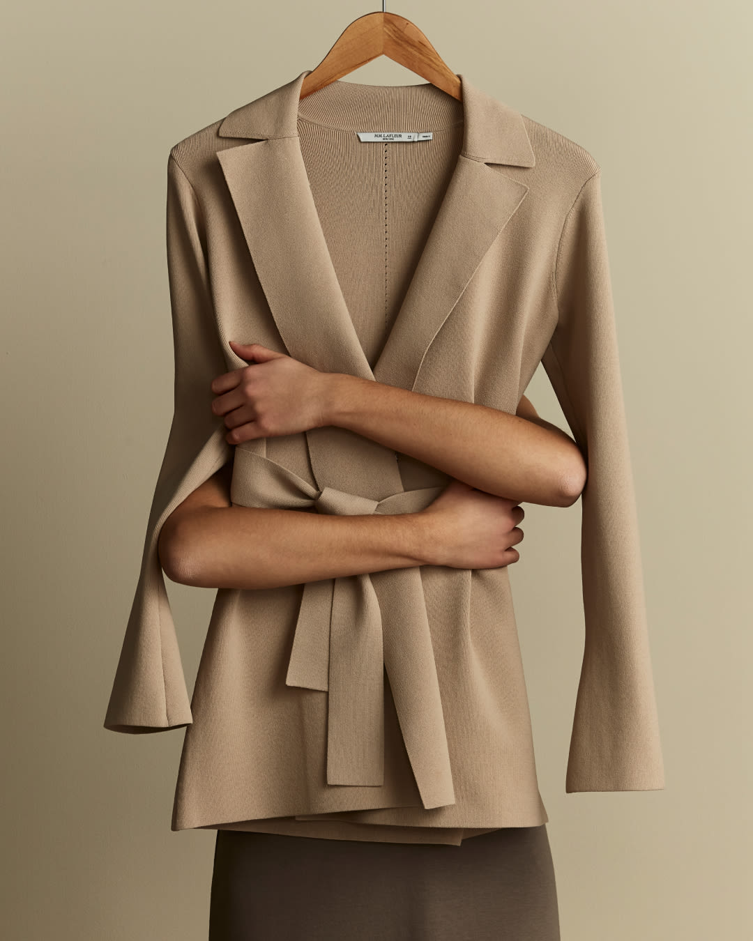 arms hugging a latte-colored Merritt jardigan on a hanger from behind