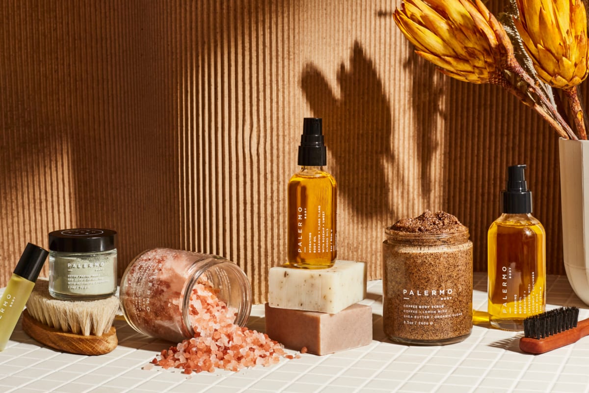 Palermo body products on a white table in front of a tan backdrop