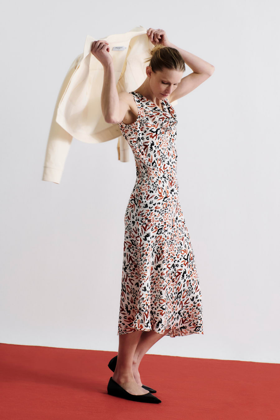image of a woman wearing the priya dress in leopard sketch with the rhoda jacket in tusk