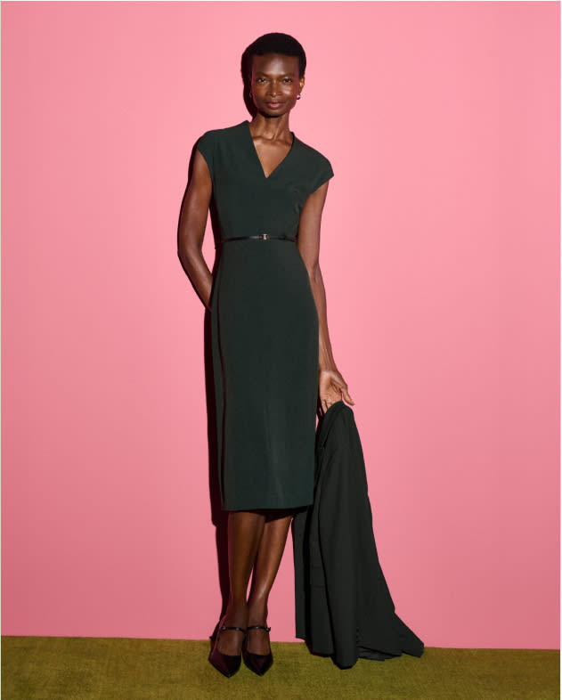 image of a woman wearing the vienna dress in dark emerald