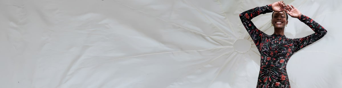 Image of a woman in the Johnna dress in splatter print in front of a white parachute