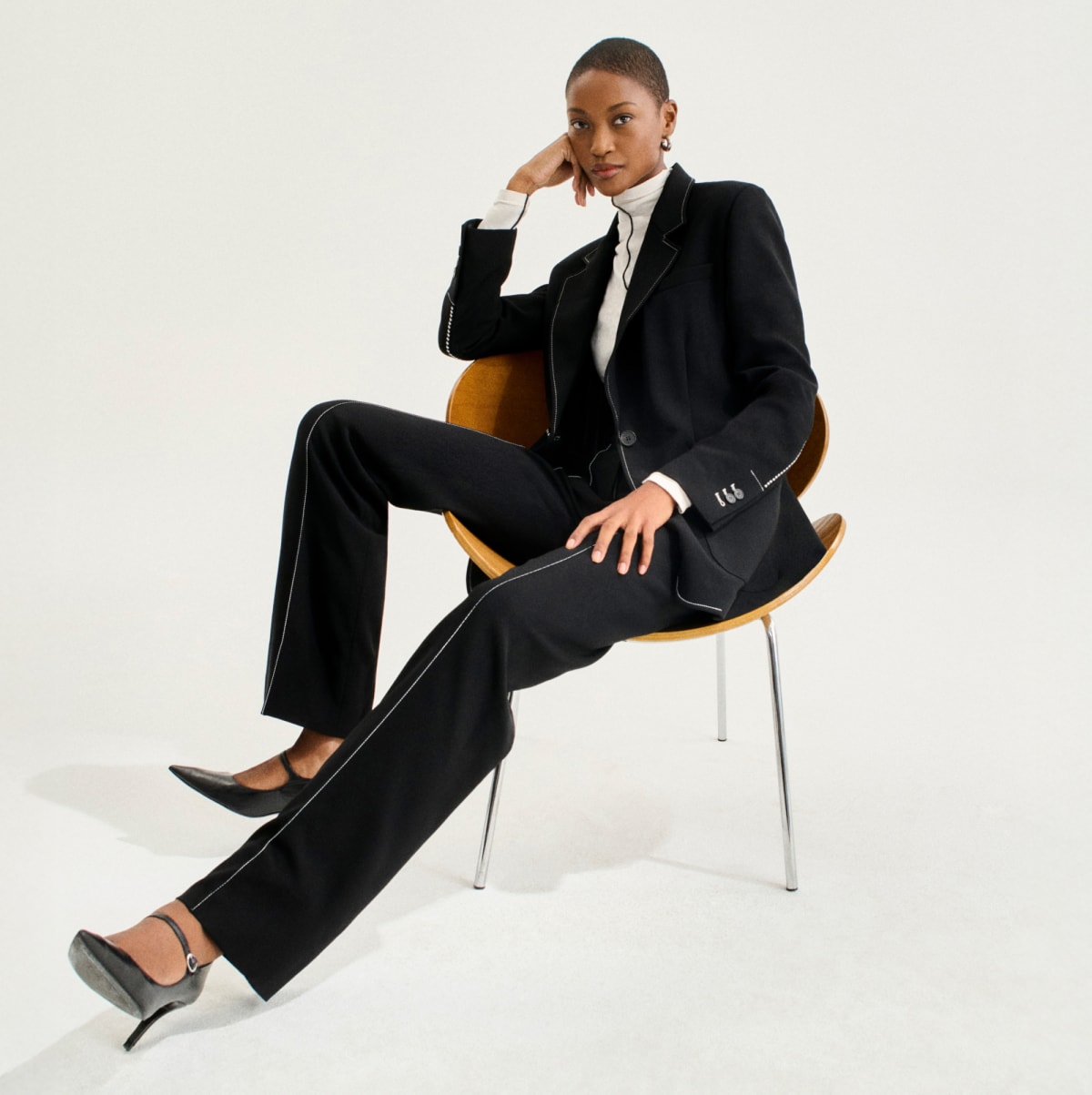 image of a woman in a black suit and white turtleneck