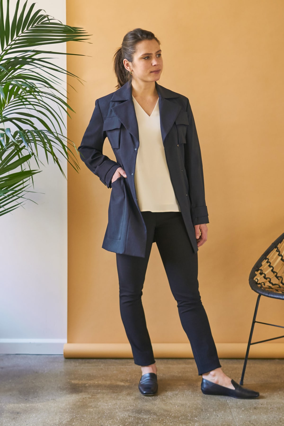 Woman standing wearing blue jacket over black skinny jeans