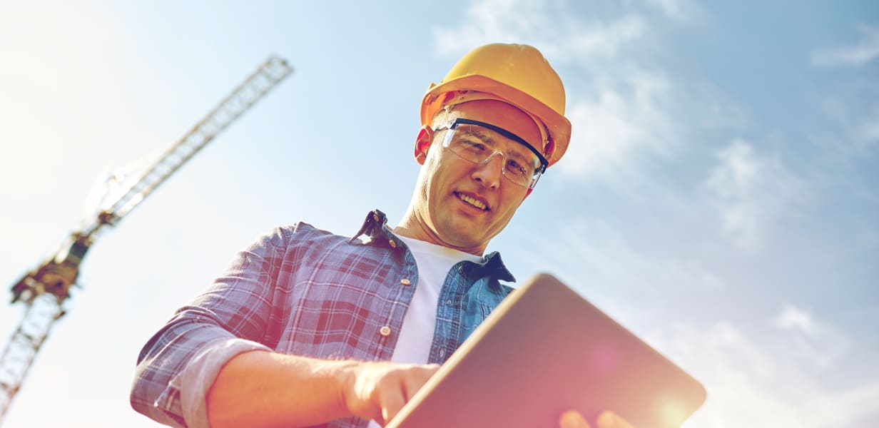 Construction worker performing workflow process management on tablet