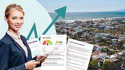 A woman holds an iPad with a rent roll performance check report next to her shoulders, standing in front of a background of a coastal town.