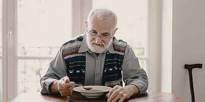 lonely elder man eating ad at rv4rbj