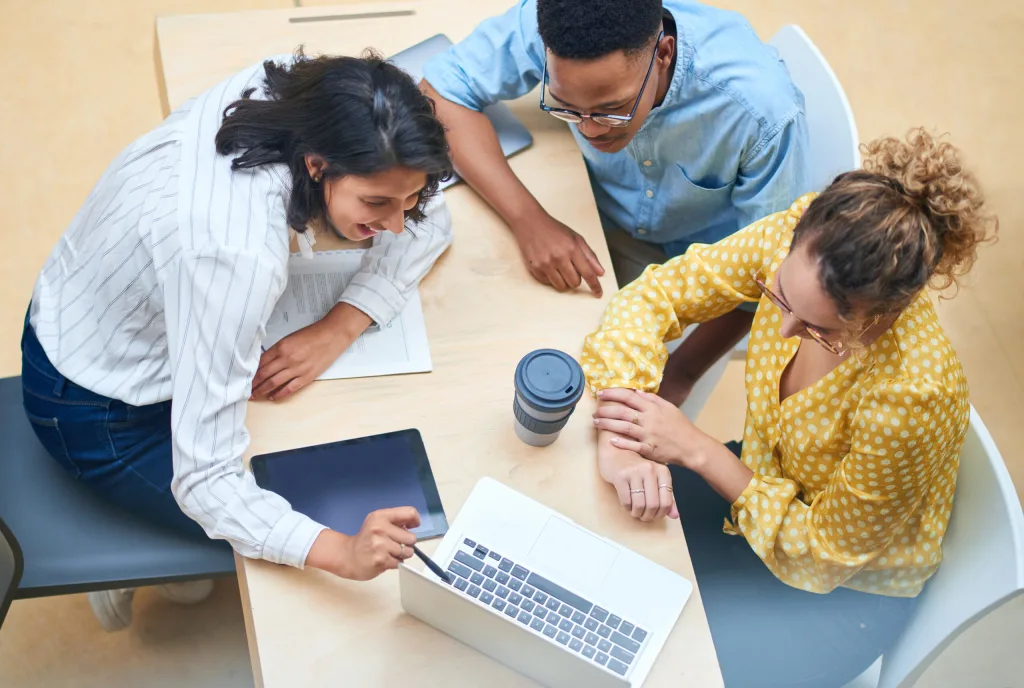 Shot of a group of young businesspeople using a laptop in a modern office