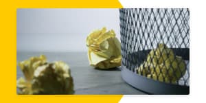 garbage can with crumpled pieces of paper