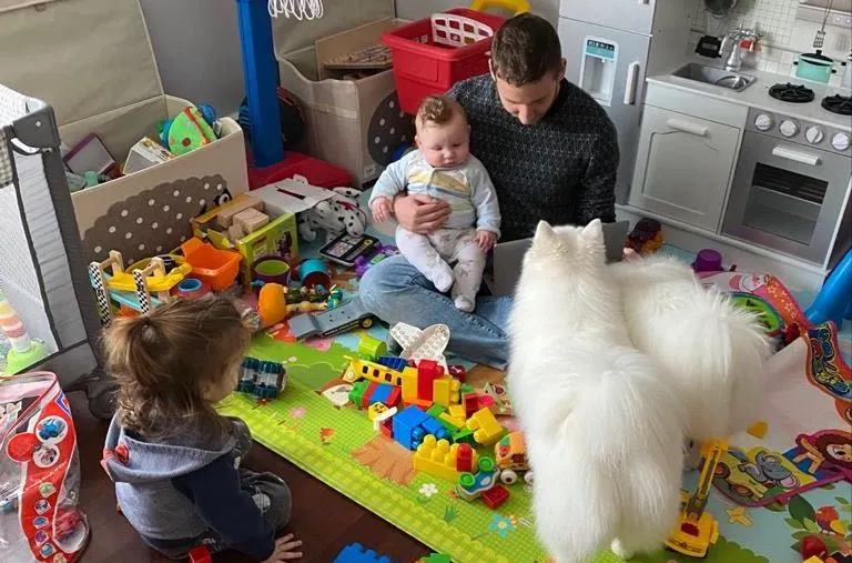 homme en train de jouer avec son bébé et son chien