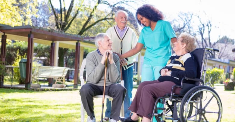 A nurse visits with several nursing home residents