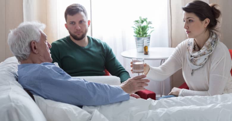 Adult children visit with their father, who is in hospice care