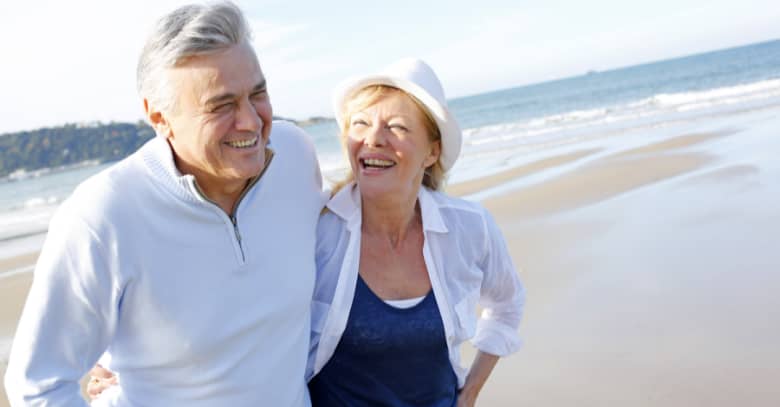 A senior couple enjoys a walk on the beach