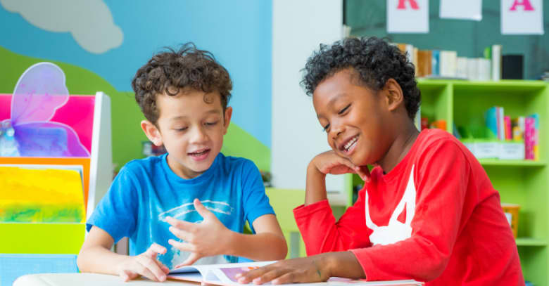 Two boys share a book at after-school care.