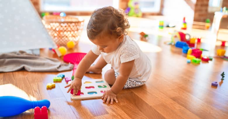 a toddler works on a puzzle at day care