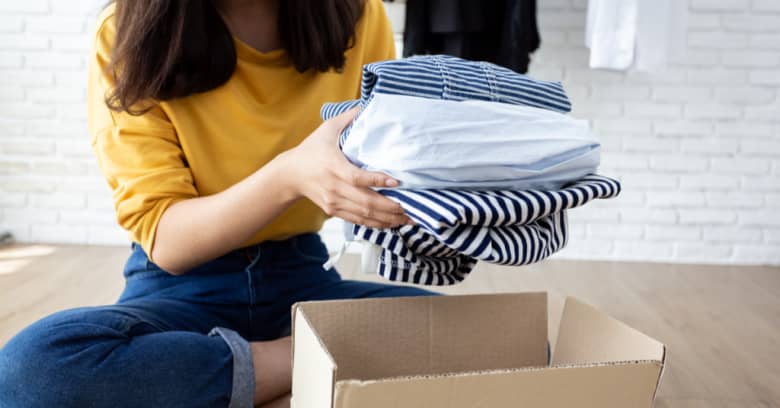 A woman gets rid of clothing and prepares to donate them to a homeless shelter