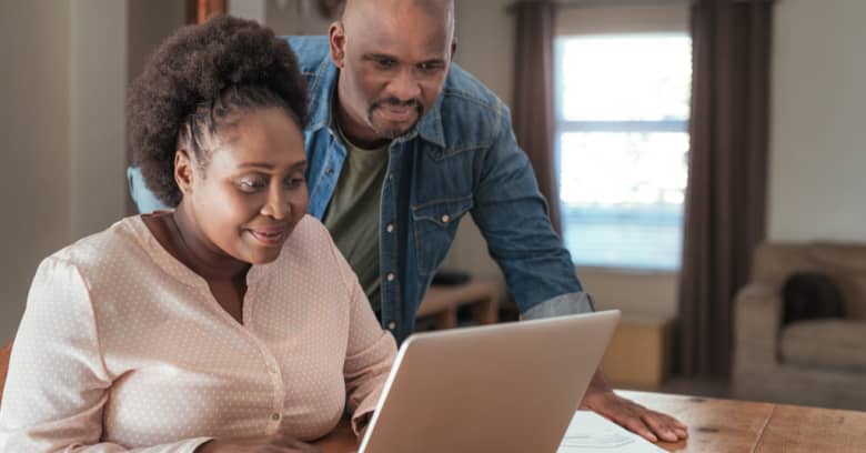 A couple uses their computer to do research on insurance requirements in their new state