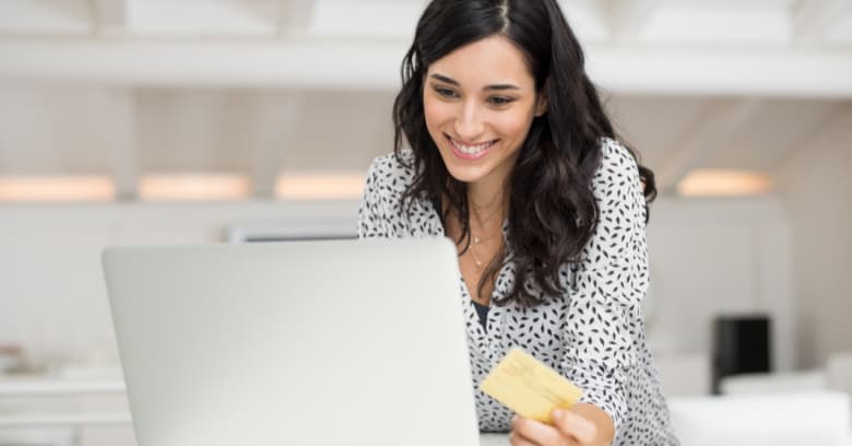 A woman holds her credit card as she prepares to pay for her auto insurance policy online