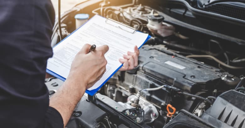 A mechanic conducts an emissions test on a vehicle