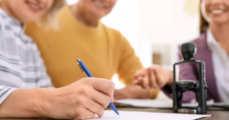 A middle-aged couple signs legal papers providing security for their adult child with disabilities