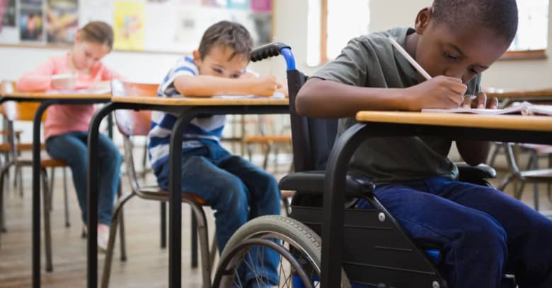 A child who uses a wheelchair works hard in his classroom.