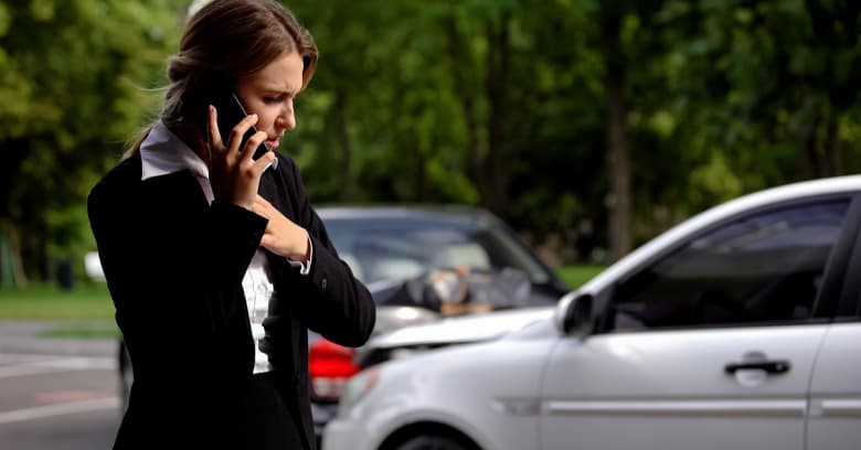 woman using her phone after a car accident