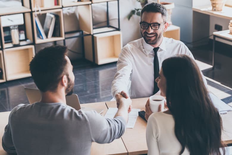 A couple sits with and talks to an advisor about their financial goals