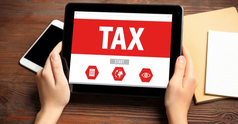 A person is holding a tablet and preparing to start the tax-filing process.