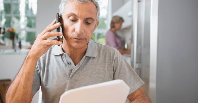 A man speaks on the phone with his insurance agent