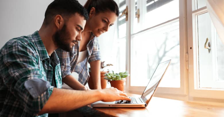 A couple looks at a computer to see if they can find cheaper insurance