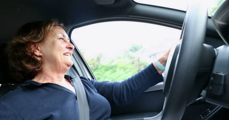 A happy mom is borrowing her son's car to run an errand.