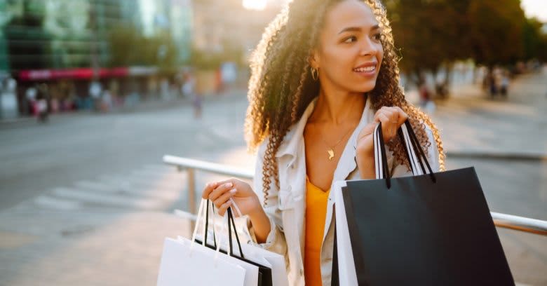 A woman holds various shopping bags.