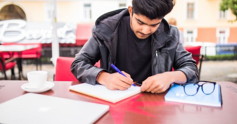  A young man writes in his notebook.