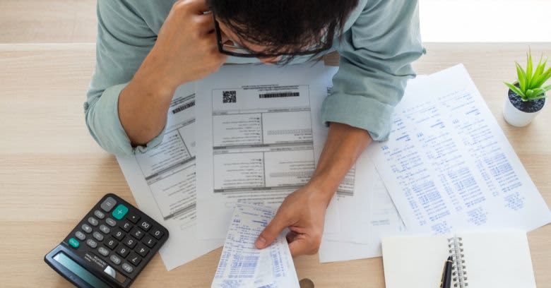 A man holds multiple receipts.