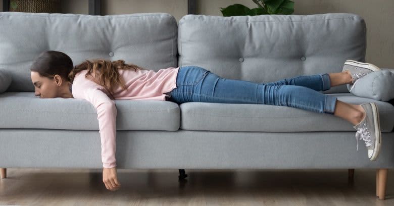 A woman lies on the couch.