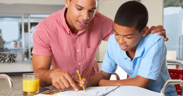 a dad helps his son with school work while they are quarantined