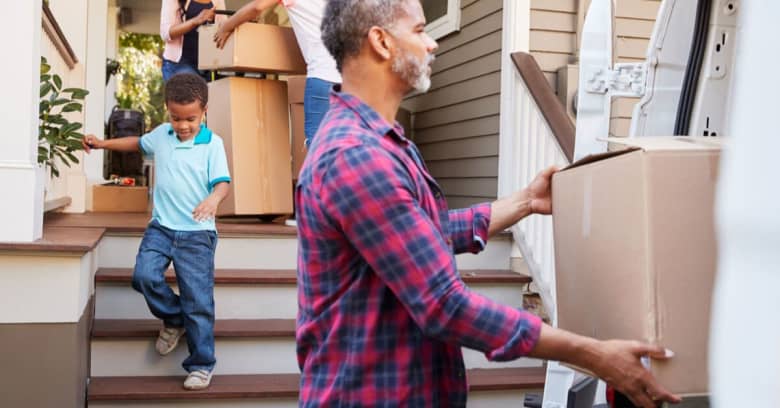 family members move boxes of personal items into their new home