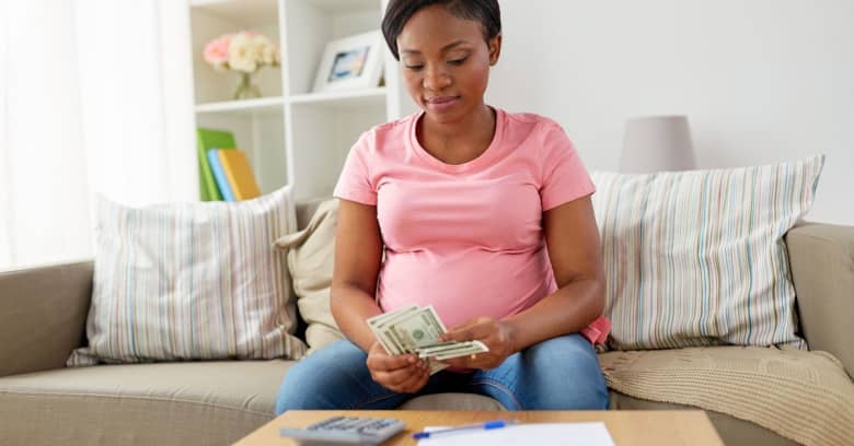 pregnant woman counting money and budgeting