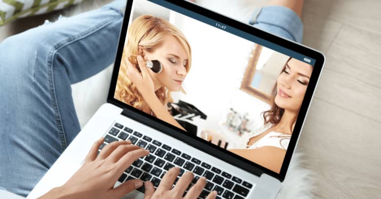 a woman watches a makeup tutorial on her computer