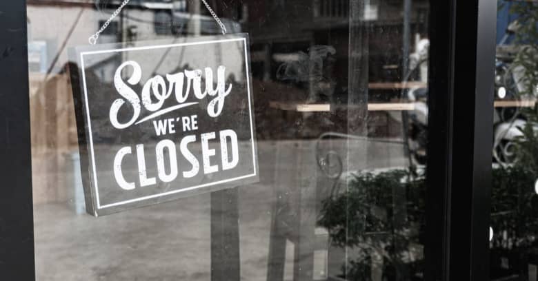 A sign that says 'sorry, we're closed' on the door to a business.