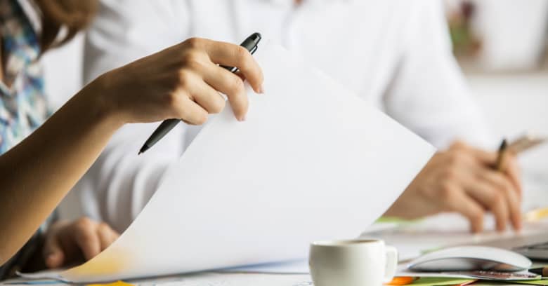 hands can be seen signing papers