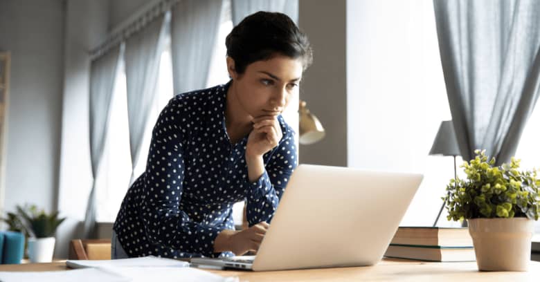a determined woman gazes at her computer