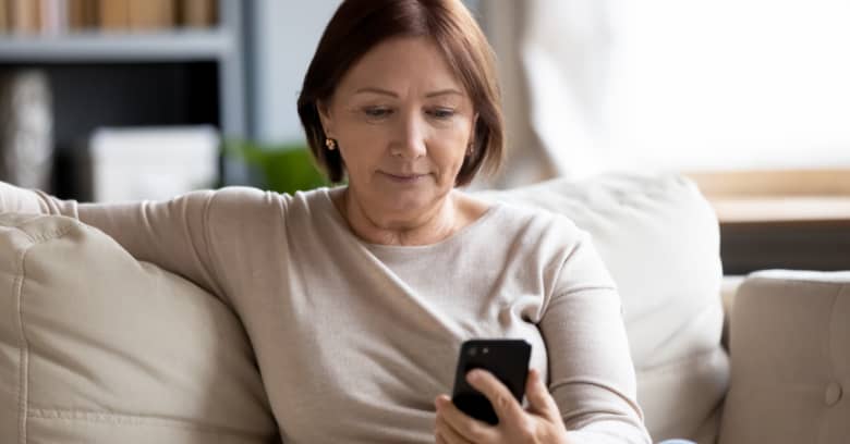 a woman looks at her phone and considers her retirement investments