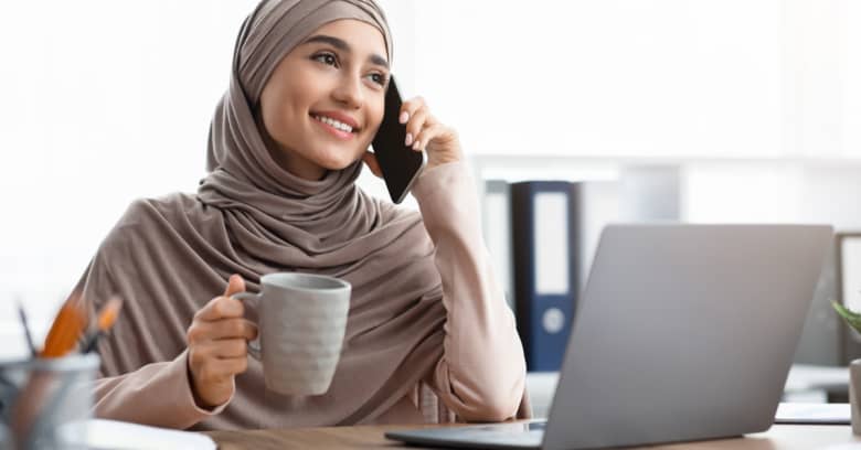 a small business owner is speaking on the phone while holding a cup of coffee