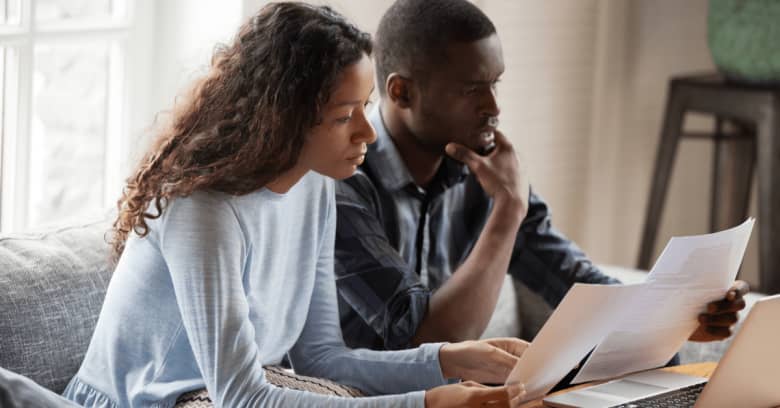 a couple gathers up documents as they prepare to file their taxes online